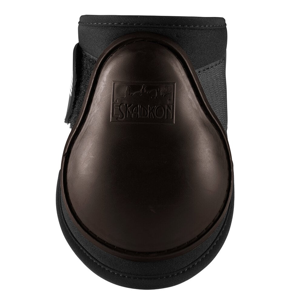 En närbild på ett brunt kotskydd med ett hårt, glänsande skyddsskal i plast. Skyddet har logotypen 'ESKADRON' präglad i mitten av plastskalet. Ovansidan och sidorna är gjorda av ett svart tygmaterial, och en vit och svart kardborreknäppning syns på den öv