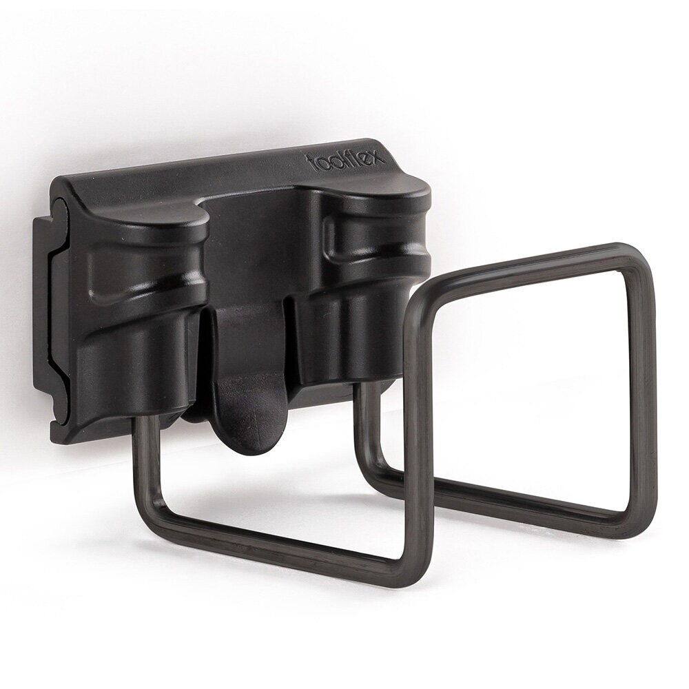 Närbild av en svart Toolflex-universalhållare i plast, som har en integrerad rektangulär krok av svart metalltråd nedtill.